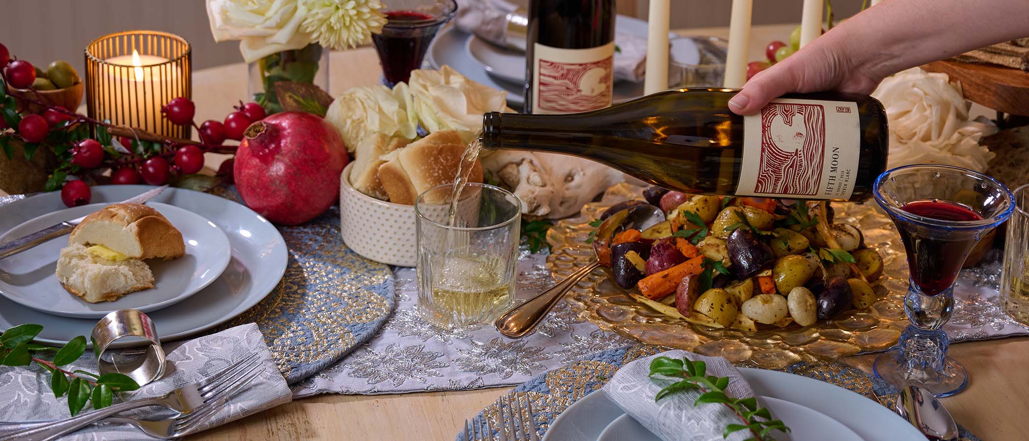 Pouring a glass of wine at Winter Solstice dinner table