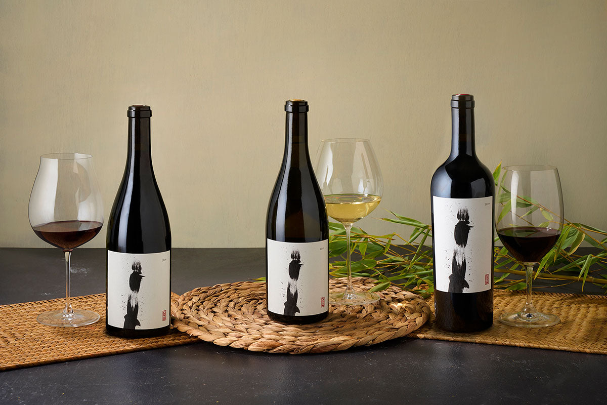 3 bottles of Khoai wine with glasses on a table