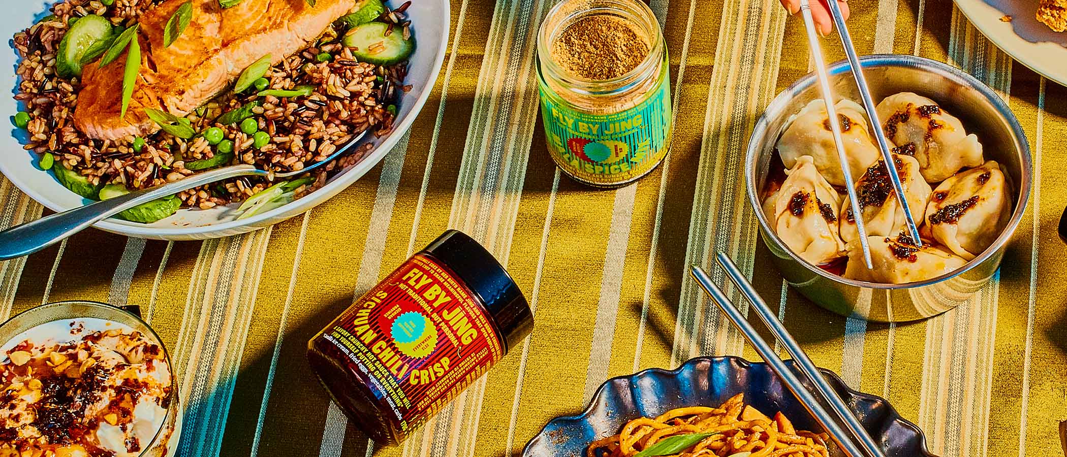 Colorful table featuring Asian dishes and Fly By Jing products