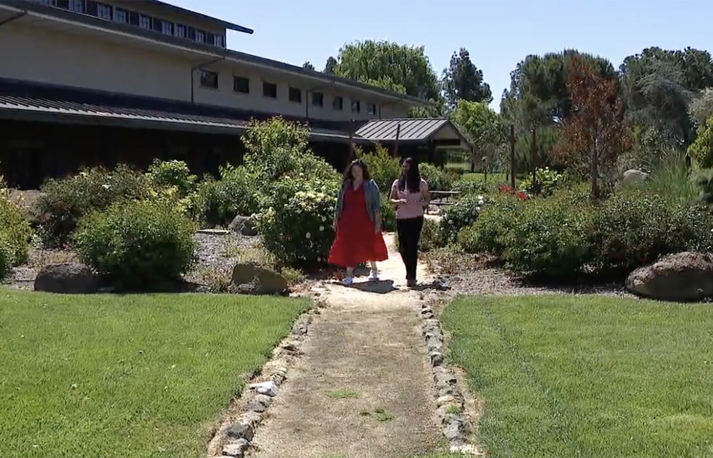 Two women walking through winery garden