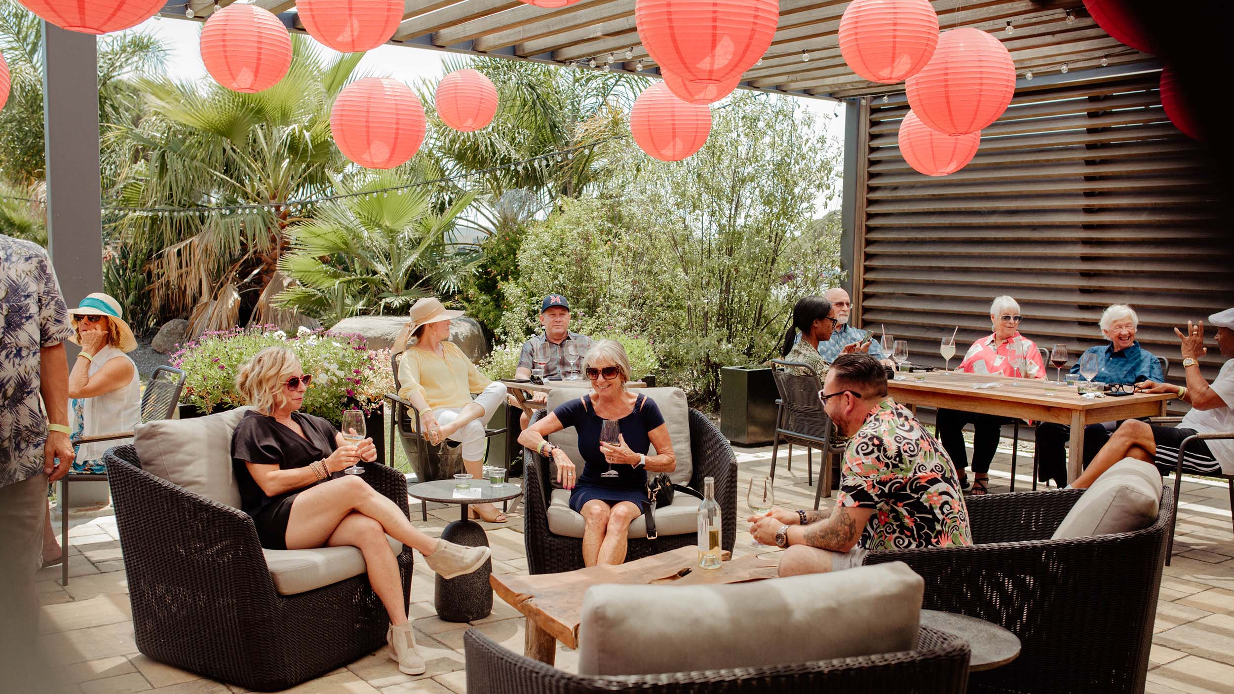 Group of guests relax on patio under red lanterns