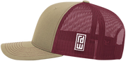 A two-tone trucker cap with a tan front panel and brim, and a burgundy mesh back, featuring a white square logo patch on the side.