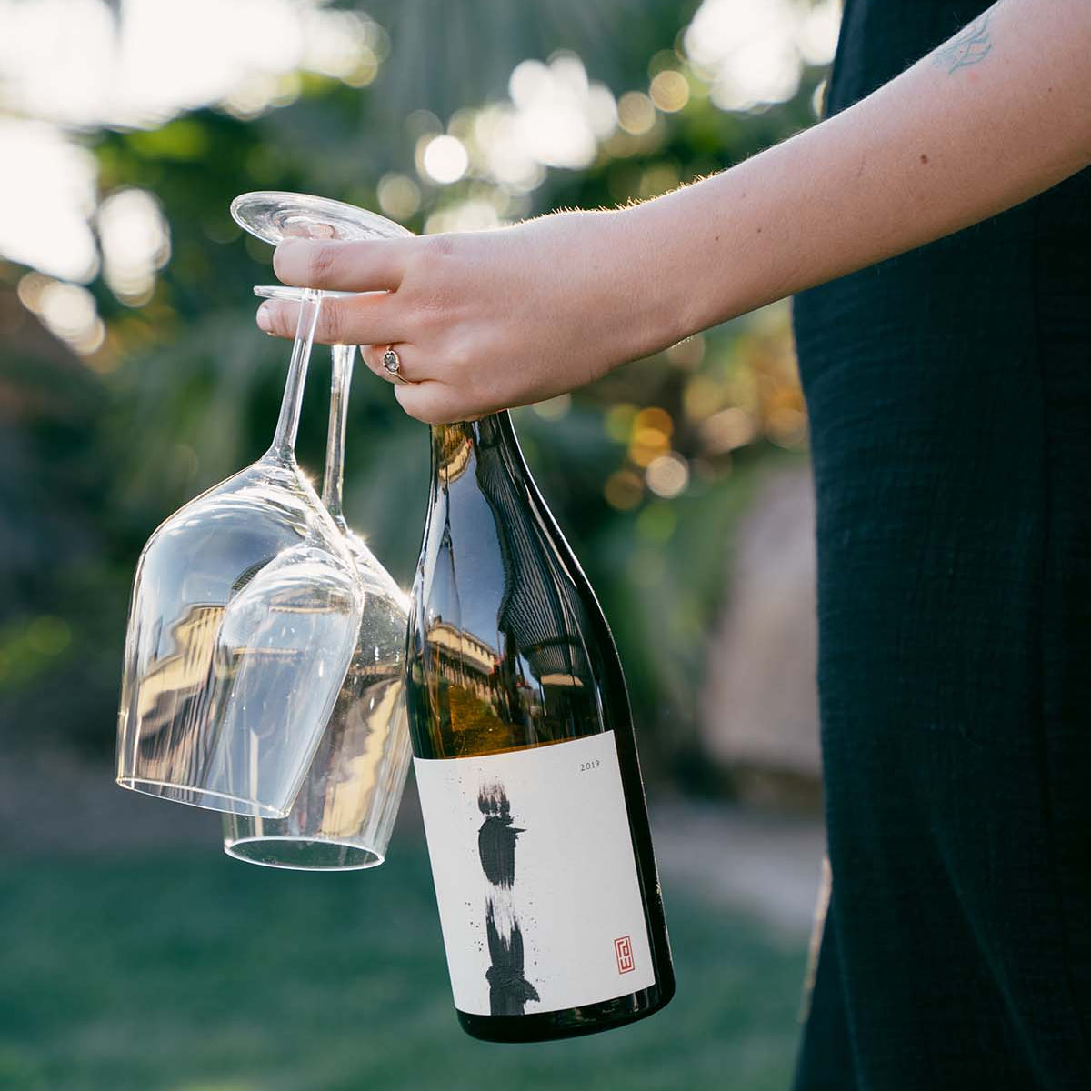 Holding a wine bottle and glasses