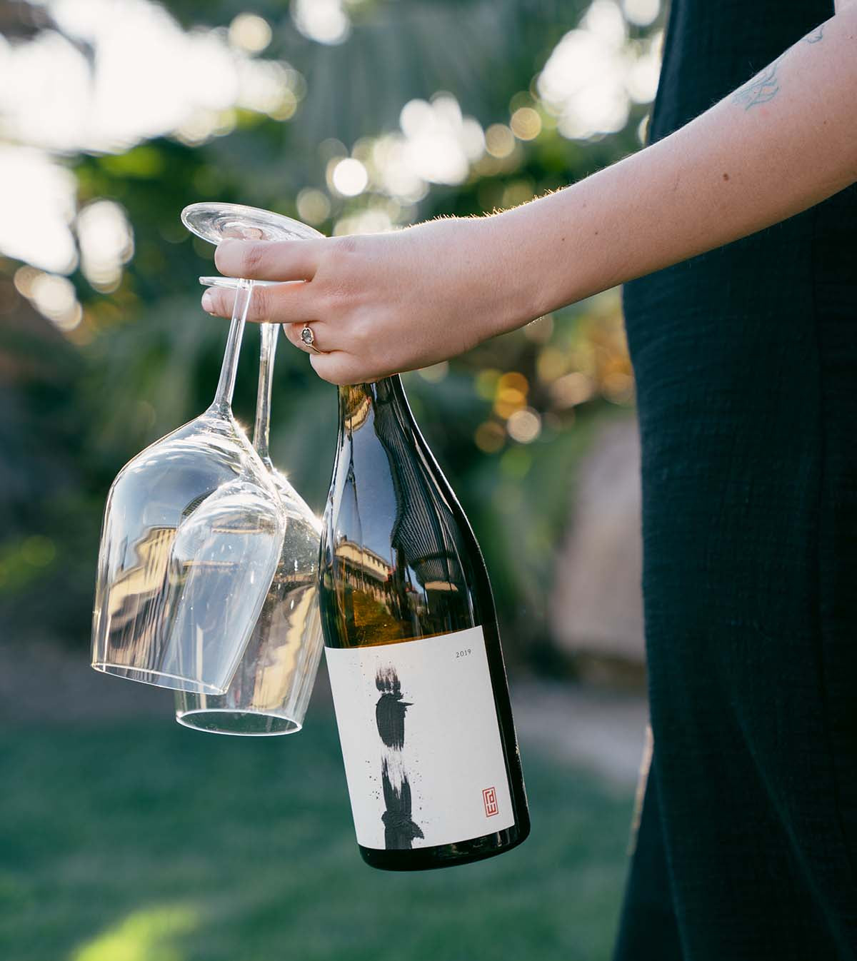 Holding a wine bottle and glasses