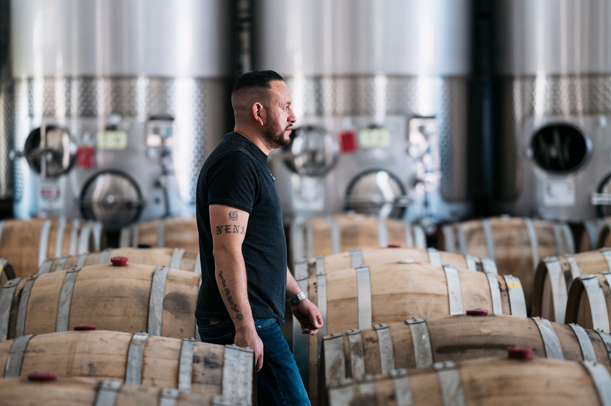man walking past barrels