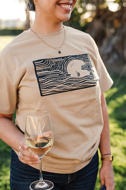 Close up of woman in khaki colored logo t-shirt