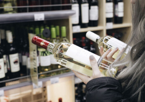 Woman choosing wine at the grocery store