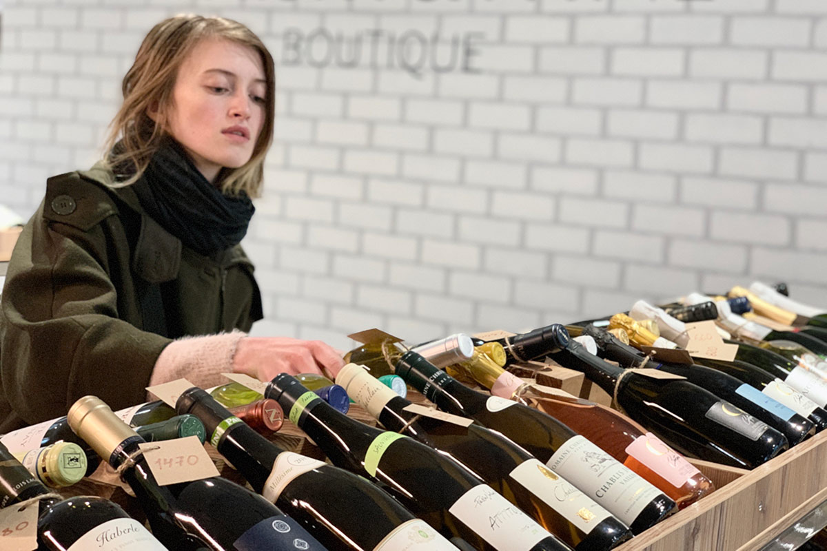 Woman deciding which wine to buy