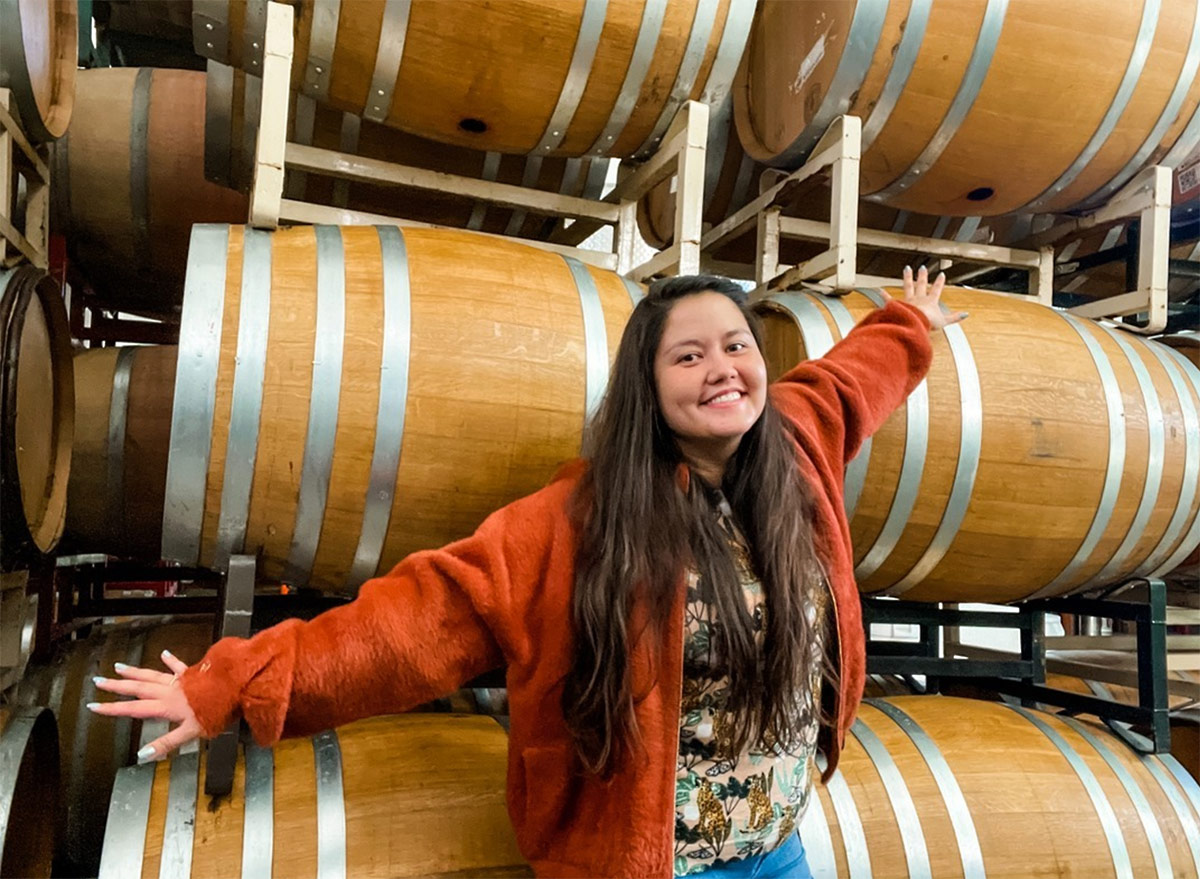 RD Winery CEO Mailynh Phan in front of barrels.