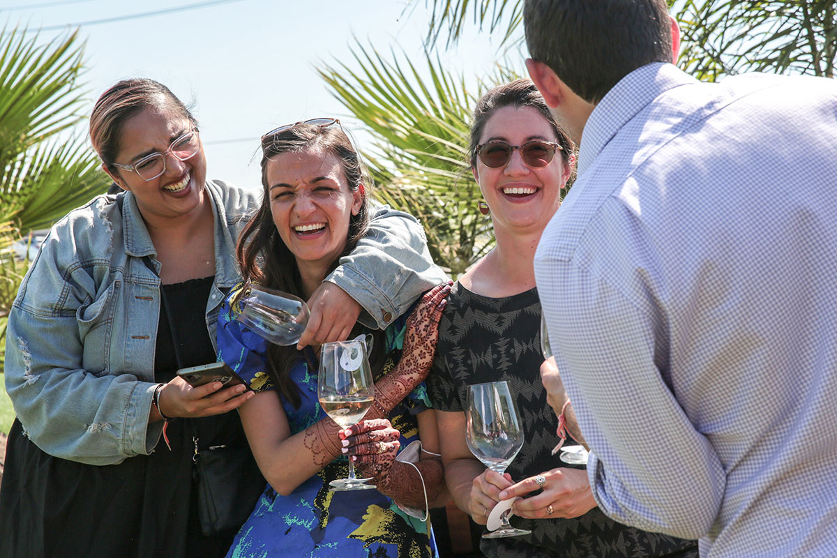 A group of guests smiling, hugging, and laughing.