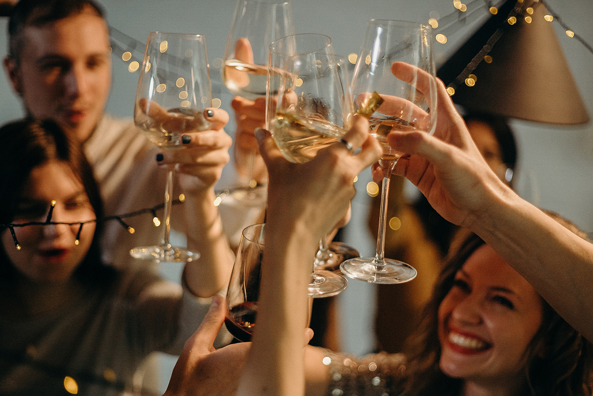 Friends toasting with white wine in their glasses.