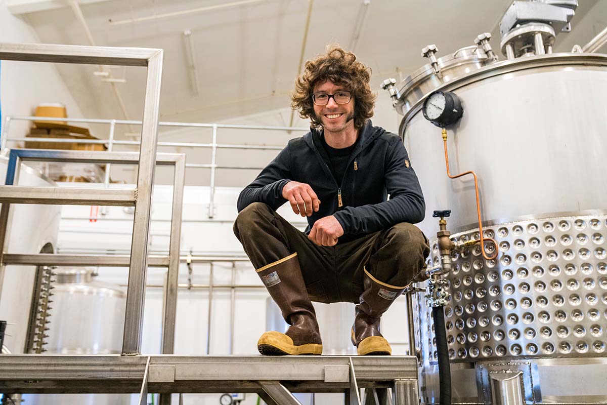 Brewer crouching on a metal catwalk