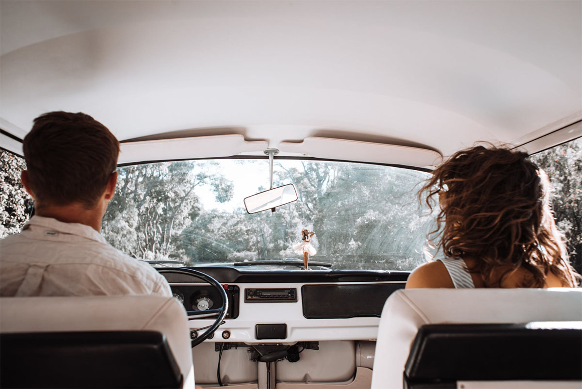 Man and woman driving in an old car