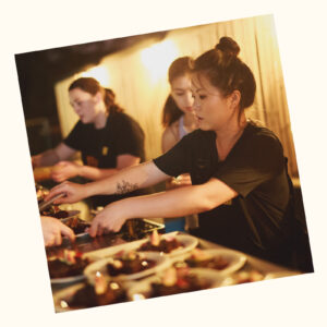 Chef Jing Gao plating dishes in busy kitchen