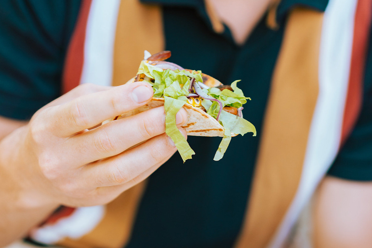 Man in striped shirt holding taco