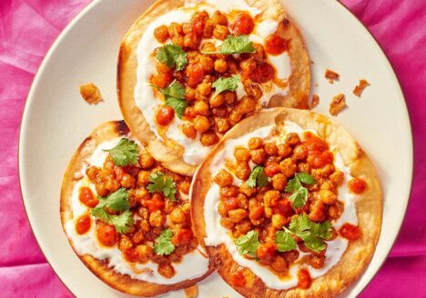 Three tostadas on a white plate and pink table cloth