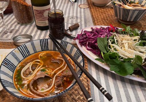 Table set with noodle soup and chopsticks on side of bowl