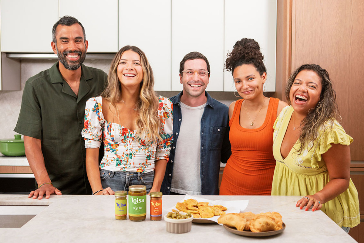 Five people standing in front of kitchen counter with Loisa products