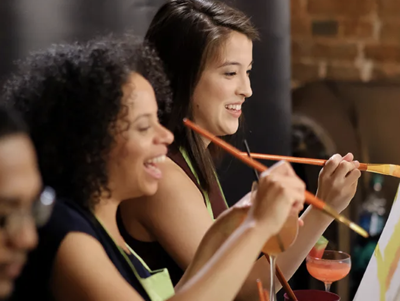 Two women painting and smiling