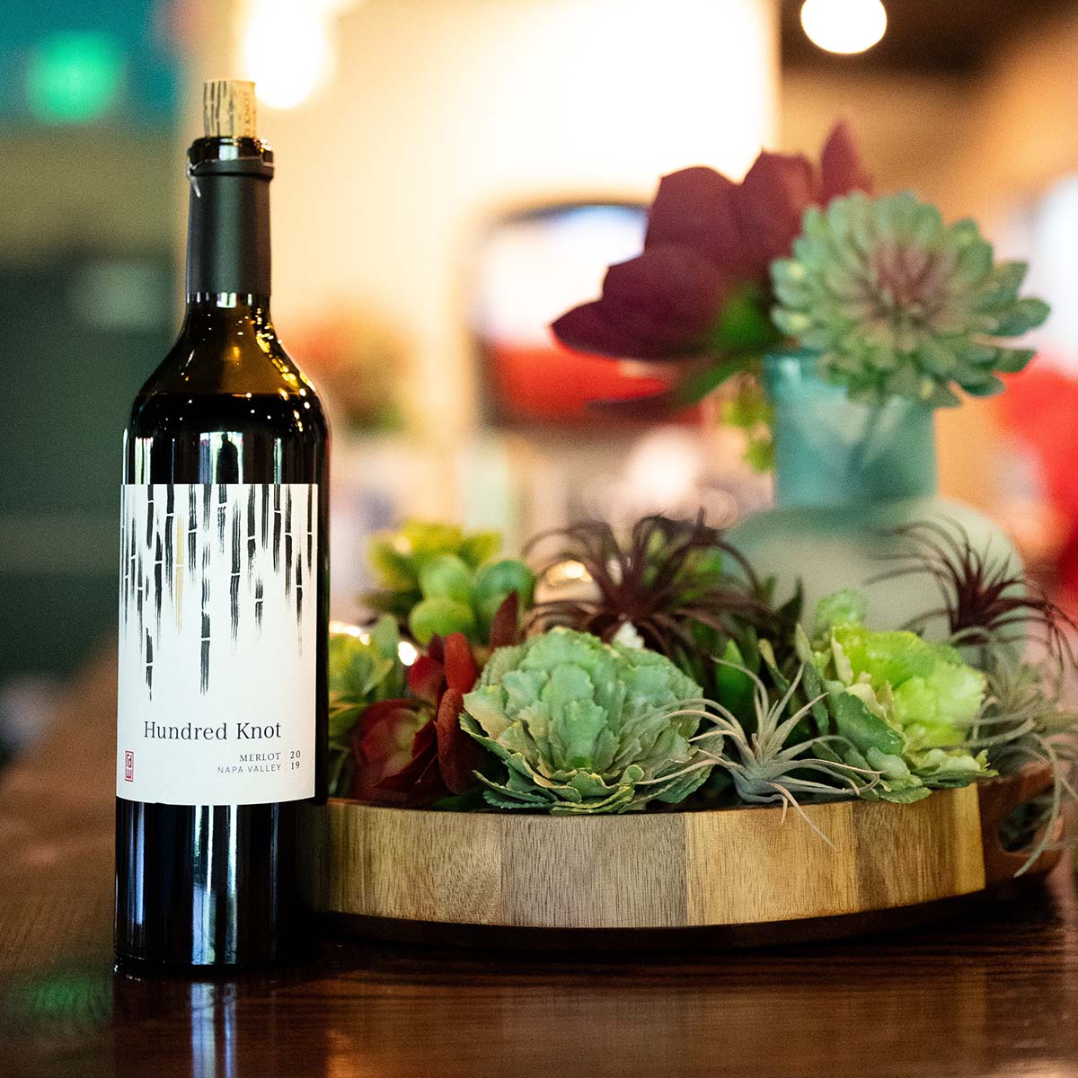 Bottle of wine in front of succulent arrangement