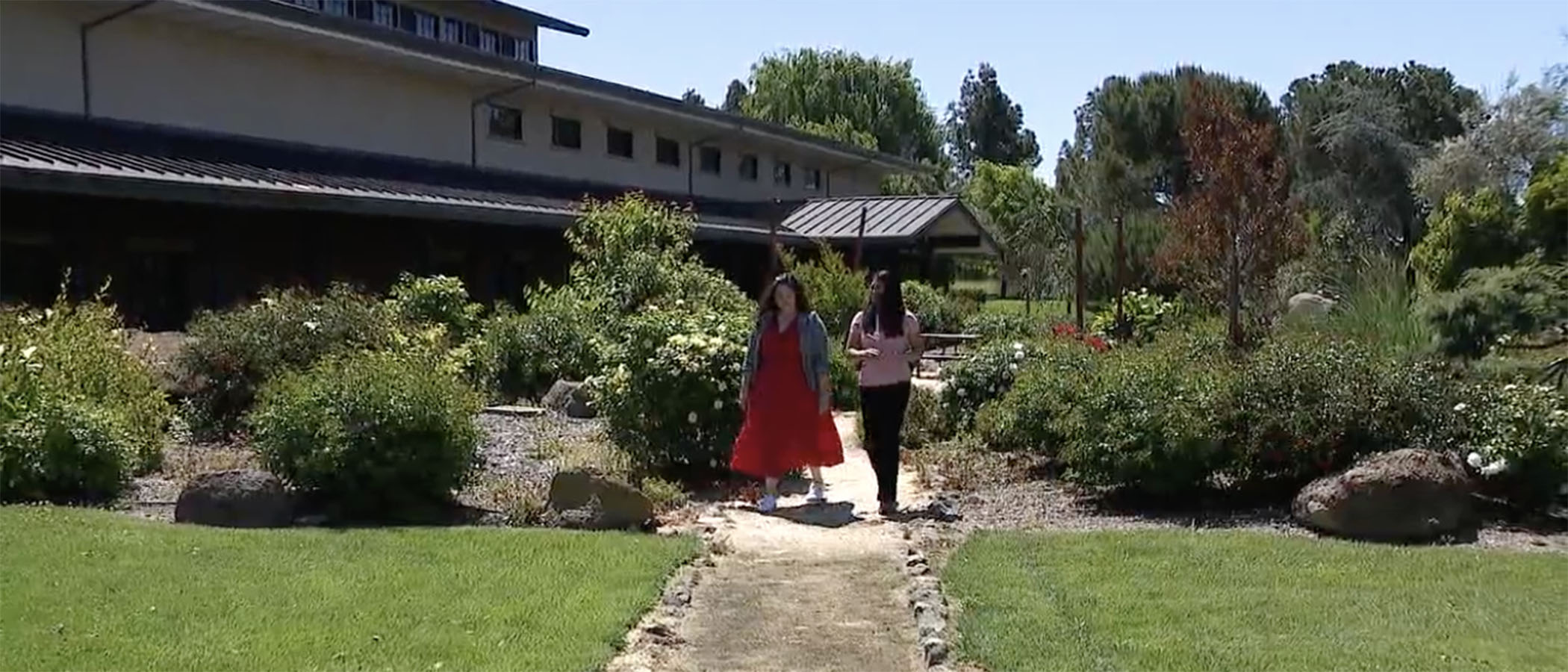 Two women walking through winery garden