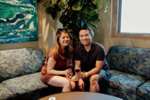 Two winery guests sitting indoors on couch