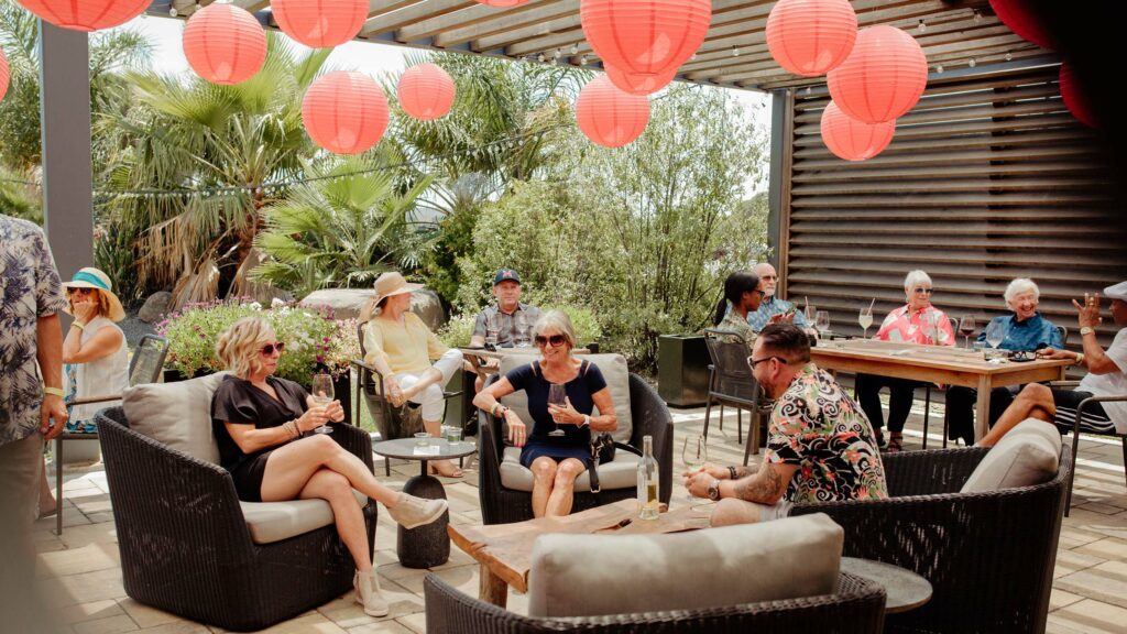 Group of guests relax on patio under red lanterns