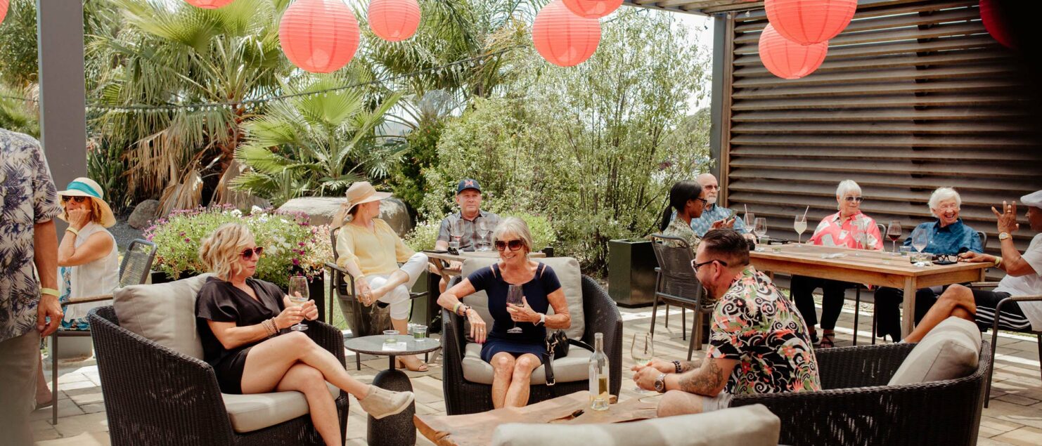 Group of guests relax on patio under red lanterns