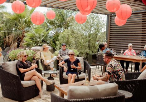 Group of guests relax on patio under red lanterns