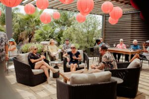 Group of guests relaxing on patio under red lanterns