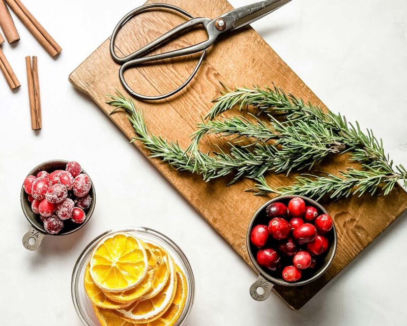 ingredients for cranberry potpourri on a cutting board and marble counter