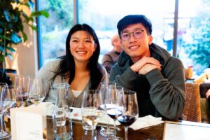 Couple sitting at table with wine glasses in foreground