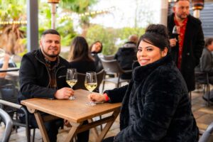 Couple sitting on patio with white wine