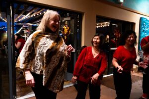 Three women dancing and smiling