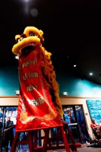 Lion dancer holding Happy Lunar New Year banner