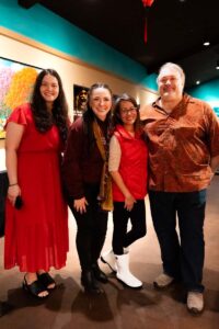 Four people in red posing and smiling together