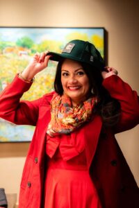 Woman in red trying on a green truck hat