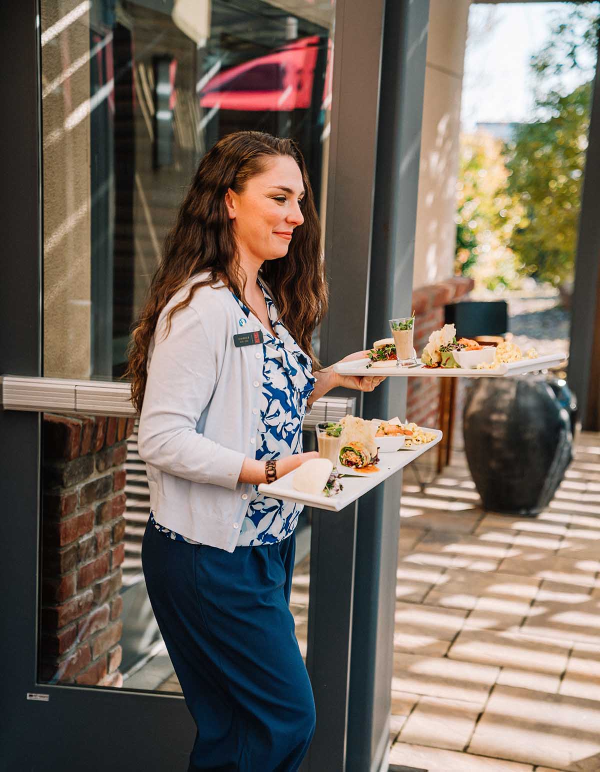 woman carrying food at napa valley wine tasting patio